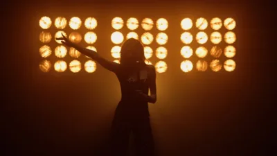 Silhouette girl musician singing mic in studio lights.