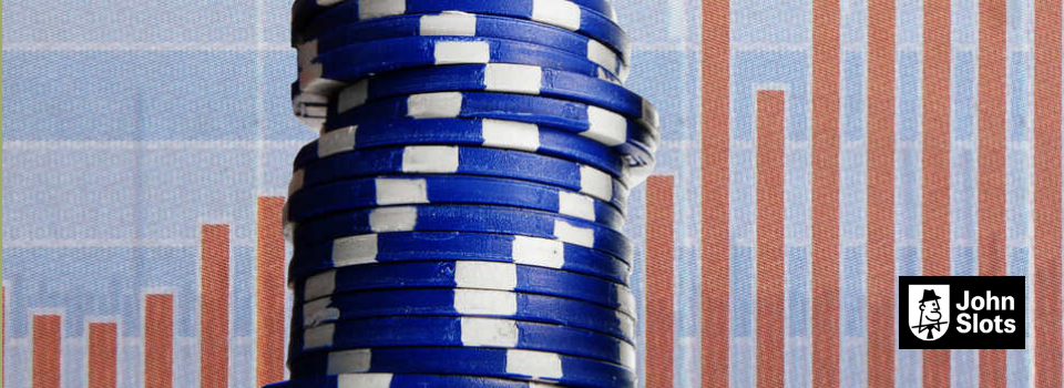 Casino chips stacked in front of a financial graph.
