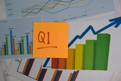 Q1 - 1st Quarter Period write on sticky notes isolated on Office Desk.
